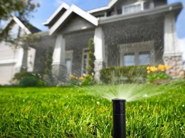Irrigation sprinkler watering green lawn